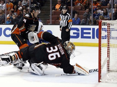 Anaheim Ducks goalie John Gibson (36) and defenseman Cam Fowler (4) watch a goal by Vancouver Canucks right wing Emerson Etem, mostly obscured, during the third period of an NHL hockey game in Anaheim, Calif., Friday, April 1, 2016. The Canucks won 3-2. (AP Photo/Alex Gallardo)