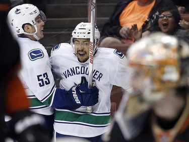 Vancouver Canucks right wing Emerson Etem (26) celebrates with center Bo Horvat (53) after scoring against the Anaheim Ducks during the third period of an NHL hockey game in Anaheim, Calif., Friday, April 1, 2016. The Canucks won 3-2. (AP Photo/Alex Gallardo)
