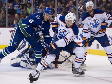 Edmonton Oilers #28 Lauri Korpikoski looks to pass despite pressure from Vancouver Canucks #88 Nikita Tryamkin during the second period of the final regular season NHL hockey game at Rogers Arena, Vancouver April 09 2016. ( Gerry Kahrmann  /  PNG staff photo)  ( For Prov / Sun Sports )  00042613A  [PNG Merlin Archive]