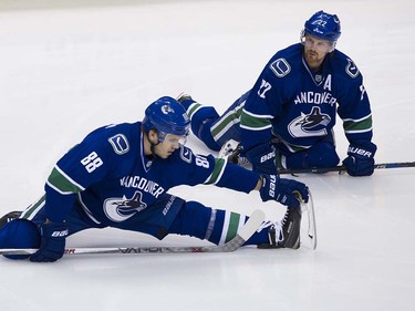 Vancouver Canucks #88 Nikita Tryamkin and #22 Daniel Sedin stretch during the pre game skate prior to playing the Edmonton Oiler in the final regular season NHL hockey game at Rogers Arena, Vancouver April 09 2016. ( Gerry Kahrmann  /  PNG staff photo)  ( For Prov / Sun Sports )  00042613A  [PNG Merlin Archive]