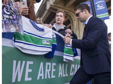 Canucks player Dan Hamhuis signs autographs for fans as they meet the players at Pat Quinn Way outside Rogers Arena prior to the last game of the regular season, Vancouver April 09 2016. ( Gerry Kahrmann  /  PNG staff photo)  ( For Prov / Sun Sports )  00042648A  [PNG Merlin Archive]