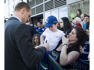 Canucks player Henrik Sedin signs autographs for fans as they meet the players at Pat Quinn Way outside Rogers Arena prior to the last game of the regular season, Vancouver April 09 2016. ( Gerry Kahrmann  /  PNG staff photo)  ( For Prov / Sun Sports )  00042648A  [PNG Merlin Archive]