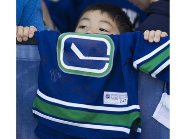 Canucks fanJoshua Yu peers over the fence to look for players at Pat Quinn Way outside Rogers Arena prior to the last game of the regular season, Vancouver April 09 2016. ( Gerry Kahrmann  /  PNG staff photo)  ( For Prov / Sun Sports )  00042648A  [PNG Merlin Archive]