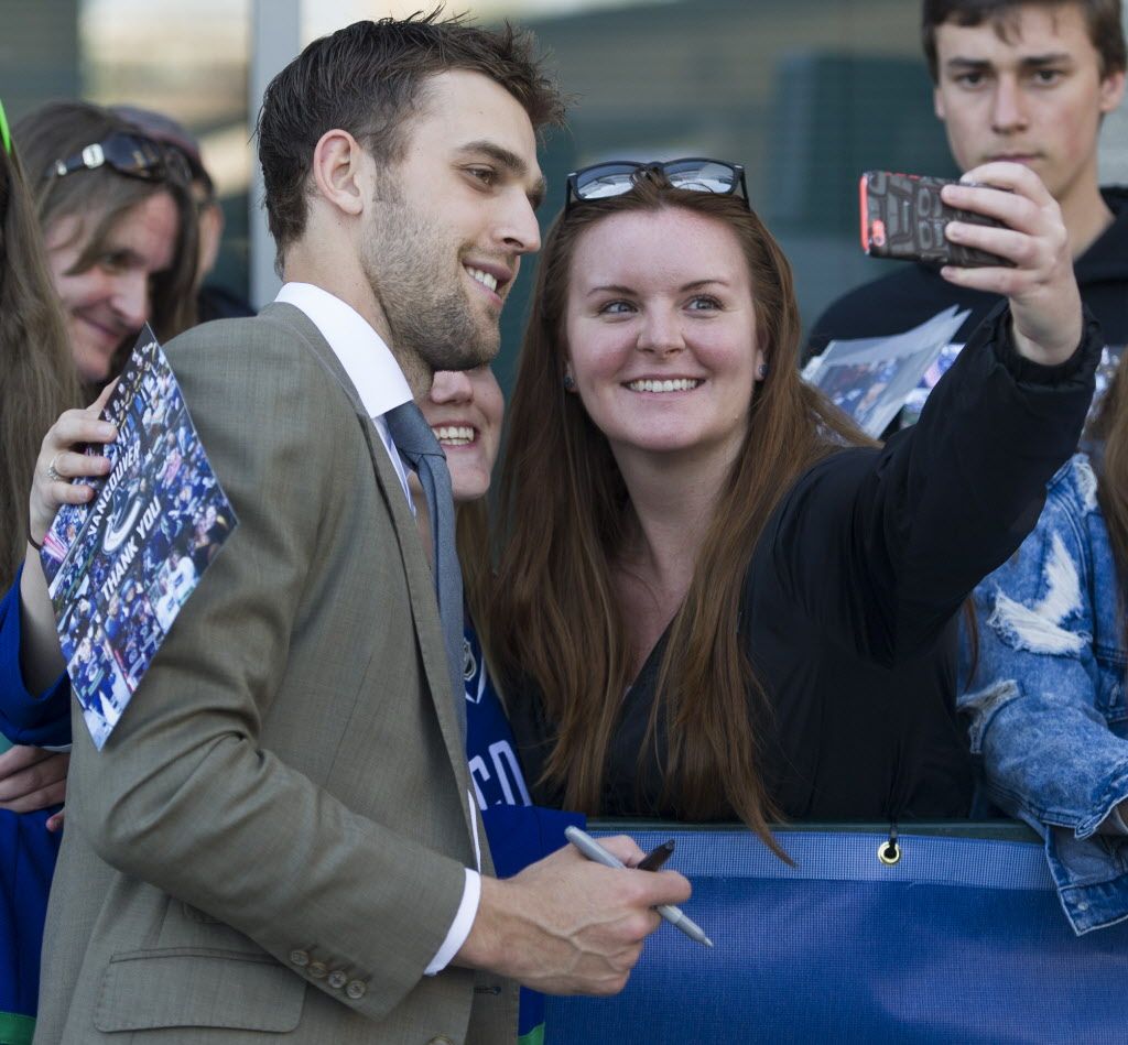 Brandon Sutter has his photo taken with a fan at Pat Quinn Way outside Rogers Arena prior to the last game of the regular season, Vancouver April 09 2016.