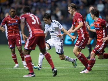 Vancouver Whitecaps' Nicolas Mezquida, centre, moves the ball past FC Dallas' Walker Zimmerman, fourth left, as Carlos Gruezo (7), Maynor Figueroa (31) and Zach Loyd (17) watch during the second half in Vancouver, B.C., on April 23, 2016.
