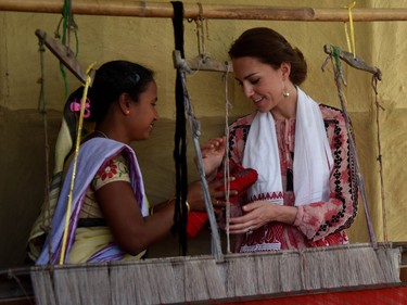 An Indian woman presents a hand woven cloth to Britain's Kate, the Duchess of Cambridge, in Panbari village, east of Gauhati, northeastern Assam state, India, Wednesday, April 13, 2016.