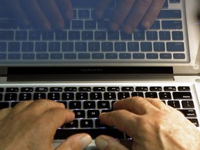 FILE - In this Feb. 27, 2013 photo illustration, hands type on a computer keyboard in Los Angeles.