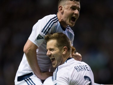 Vancouver Whitecaps' Jordan Harvey, right, Fraser Aird, top, and Tim Parker celebrate Harvey's goal against FC Dallas during the second half of an MLS soccer game in Vancouver, B.C., on April 23, 2016.