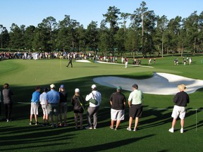 Golf fans follow Phil Mickelson as he approaches the green during a practice round on Tuesday, prior to Thursday’s start of the 80th Masters Golf Tournament at the Augusta National Golf Club in Augusta, Ga.