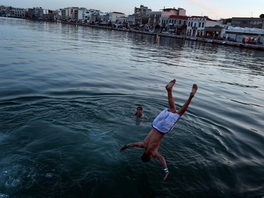 A young man dives into the water at the port of Chios, where refugees and migrants who managed to leave the VIAL detention center a few days ago are camping out on April 4, 2016. Greece sent a first wave of migrants back to Turkey on April 4 under an EU deal that has faced heavy criticism from rights groups. Under the agreement, designed to halt the main influx which comes from Turkey, all "irregular migrants" arriving since March 20 face being sent back, although the deal calls for each case to be examined individually.