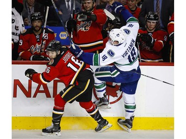 Vancouver Canucks' Jake Virtanen, right, is checked by Calgary Flames' Josh Jooris during second period NHL hockey action in Calgary, Thursday, April 7, 2016.THE CANADIAN PRESS/Jeff McIntosh