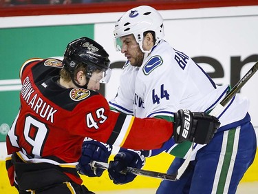 Vancouver Canucks' Matt Bartkowski, right, collides with Calgary Flames' Hunter Shinkaruk during second period NHL hockey action in Calgary, Thursday, April 7, 2016.THE CANADIAN PRESS/Jeff McIntosh