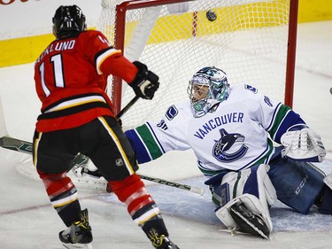 Vancouver Canucks goalie Ryan Miller, right, looks back as Calgary Flames' Mikael Backlund, from Sweden, scores during first period NHL hockey action in Calgary, Thursday, April 7, 2016.THE CANADIAN PRESS/Jeff McIntosh