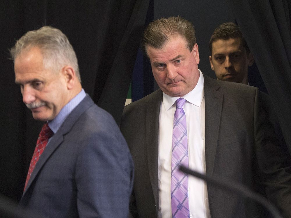 Vancouver Canucks general manager Jim Benning, right, and head coach Willie Desjardins arrive for a news conference in Vancouver, B.C., Tuesday, April 12, 2016. THE CANADIAN PRESS/Jonathan Hayward
