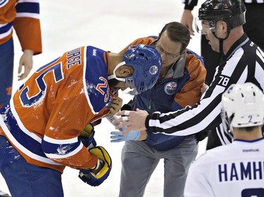 Edmonton Oilers' Darnell Nurse (25) receives treatment after being injured against the Vancouver Canucks during first period NHL action in Edmonton, Alta., on Wednesday April 6, 2016. THE CANADIAN PRESS/Jason Franson