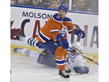 Vancouver Canucks' Dan Hamhuis (2) is checked by Edmonton Oilers' Andrej Sekera (2) during first period NHL action in Edmonton, Alta., on Wednesday April 6, 2016. THE CANADIAN PRESS/Jason Franson