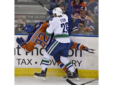 Vancouver Canucks' Emerson Etem (26) checks Edmonton Oilers' Jordan Oesterle (82) during first period NHL action in Edmonton, Alta., on Wednesday April 6, 2016. THE CANADIAN PRESS/Jason Franson