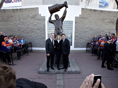 Wayne Gretzky takes pictures with fans in front of his statue before NHL action between the Vancouver Canucks and Edmonton Oilers in Edmonton, Alta., on Wednesday April 6, 2016. It will be the Oilers' last game at the only arena they've ever known, dating back to the World hockey Association in the 1970s. THE CANADIAN PRESS/Jason Franson