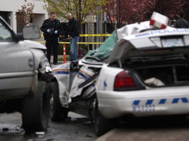 Investigators examine the scene of the crash involving a police car and a pickup truck in Langford, B.C., Tuesday, April 5, 2016. RCMP Const. Sarah Beckett was killed in the crash.