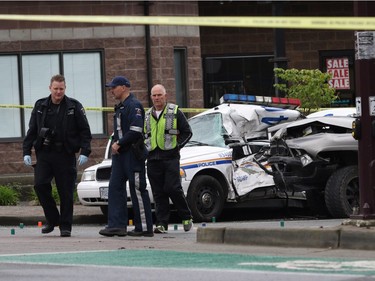 Investigators examine the scene of the crash involving a police car and a pickup truck in Langford, B.C., Tuesday, April 5, 2016. RCMP Const. Sarah Beckett was killed in the crash.