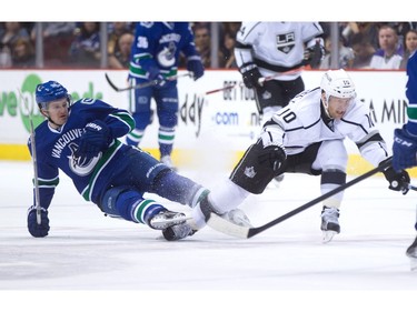 Vancouver Canucks' Jared McCann, left, falls to the ice after getting tangled up with Los Angeles Kings' Kris Versteeg during the first period of an NHL hockey game in Vancouver, B.C., on Monday April 4, 2016.