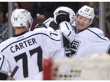 Los Angeles Kings' Tyler Toffoli, right, celebrates his goal against the Vancouver Canucks with teammates Jeff Carter (77) and Drew Doughty, back, during the first period of an NHL hockey game in Vancouver, B.C., on Monday April 4, 2016.