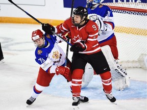 Canada's Jennifer Wakefield gets her stick up as she battles with Russia's Anna Shibanova (left) in front of Russia's net during their Tuesday game at the women's world hockey championships in Kamloops.