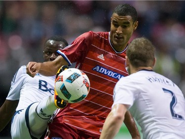Vancouver Whitecaps' Kekuta Manneh, back left, gets his foot on the ball from behind FC Dallas' Tesho Akindele, centre, as Whitecaps' Jordan Harvey, right, defends during the first half of an MLS soccer game in Vancouver, B.C., on April 23, 2016.
