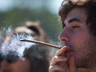 A man smokes during the annual 4/20 cannabis culture celebration at Sunset Beach in Vancouver, B.C., on Wednesday April 20, 2016.