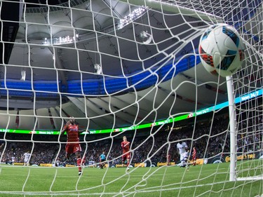 The ball strikes the back of the net after Vancouver Whitecaps' Kekuta Manneh, back right, scored as FC Dallas' Maynor Figueroa (31) and Zach Loyd (17) watch during the second half of an MLS soccer game in Vancouver, B.C., on April 23, 2016.