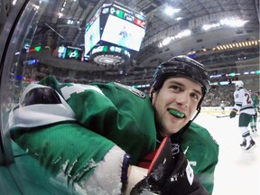 Jamie Benn of the Dallas Stars is all smiles after being checked into the boards by the Minnesota Wild in the first period in Game 2 of their opening-round NHL Stanley Cup playoff series at American Airlines Center in Dallas on April 16, 2016.