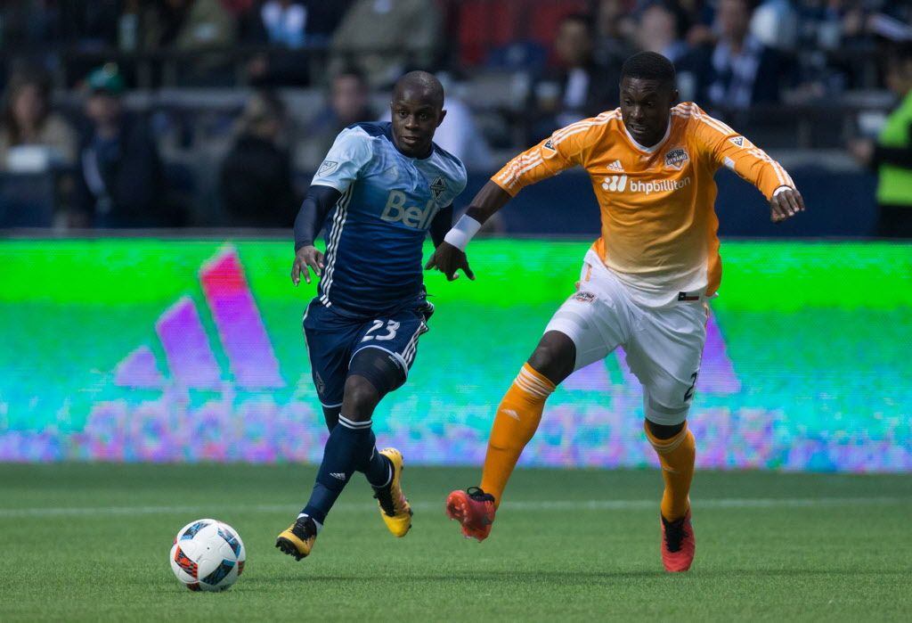Vancouver Whitecaps' Kekuta Manneh, left, moves the ball past Houston Dynamo's Jalil Anibaba.