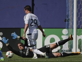 New York City FC goalkeeper Josh Saunders dives to block a shot attempt by Vancouver Whitecaps forward Octavio Rivero in NYC's 3-2 victory at Yankee Stadium in the Bronx Saturday.