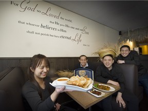 Owner Daniel Chew with chef sons William, right, and Victor, sitting, and Geneviev Khoo (front) inside John 3:16.