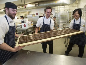 Pastry chef and chocolatier Thomas Haas (centre) with fellow chocolatiers Carrie Kwok and Curtis Helm with a massive 60-pound chocolate bar Haas created for a customer, at Haas' North Vancouver cafe.