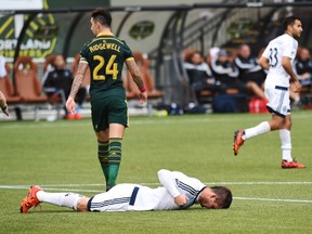 Vancouver Whitecaps forward Octavio Rivero lies on the pitch after missing a shot as Portland Timbers defender Liam Ridgewell walks away during the first half of a playoff game last season.