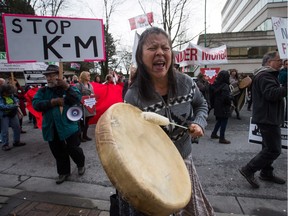 Patricia Kelly, of the Sto:lo First Nation, chants and beats a drum during a protest outside National Energy Board hearings on the proposed Trans Mountain pipeline expansion in Burnaby in January.