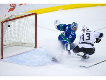 Los Angeles Kings' Kyle Clifford, right, scores against Vancouver Canucks' goalie Ryan Miller during the second period of an NHL hockey game in Vancouver, B.C., on Monday April 4, 2016.