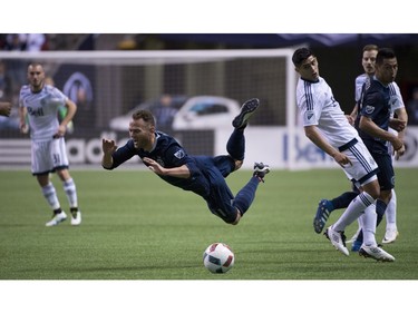 Sporting Kansas City midfielder Brad Davis (11) falls as he tries to gain control of the ball during the second half of MLS soccer action against the Vancouver Whitecaps FC in Vancouver, B.C. Wednesday, April 27, 2015.