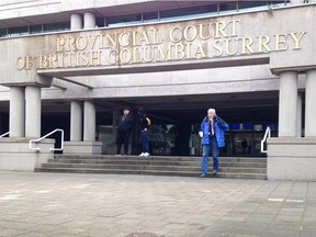 Former Langley veterinarian Wayne Etherington (right, in blue) leaves provincial court in Surrey following his first day of trial in March. Etherington was accused of two counts of sexual assault and one count of committing an indecent act. He was subsequently convicted of one count of common assault.