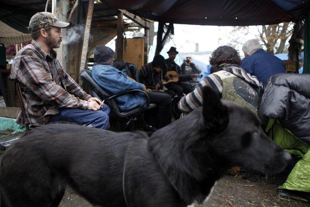 Residents at the homeless play music around the sacred fire in Victoria, B.C., Tuesday, April 5, 2016 following the injunction ruling that will allow residents to stay at Super InTent City through to September when they'll go back to supreme court. 