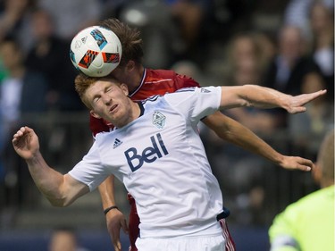 Vancouver Whitecaps' Tim Parker, front, and FC Dallas' Walker Zimmerman vie for the ball during the first half of an MLS soccer game in Vancouver, B.C., on April 23, 2016.