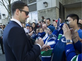 Canucks player Dan Hamhuis signs autographs for fans as they meet the players at Pat Quinn Way outside Rogers Arena prior to the last game of the regular season at the beginning of April. It may have been the last game Hamhuis played for the Canucks.
