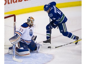 Alex Burrows fights for the puck in front of Edmonton Oilers goalie Cam Talbot during the third period of Saturday's game at Rogers Arena, in what might have been his final game as a Vancouver Canuck.