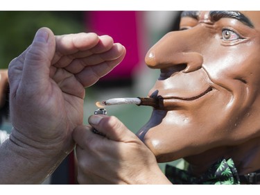 A joint is lit at a vendor's display at the annual 4:20 marijuana event at it's new location, Sunset Beach, Vancouver April 20 2016.