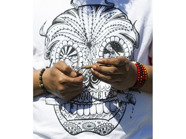 A man lights a joint at the annual 4:20 marijuana event at it's new location, Sunset Beach, Vancouver April 20 2016.