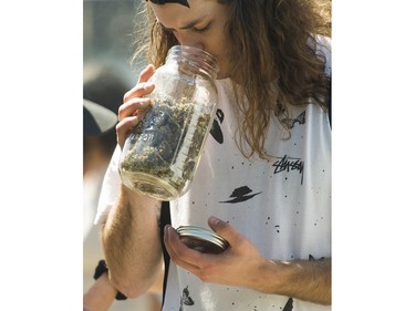 A man smells buds for sale from a vendor at the annual 4:20 marijuana event held at it's new location, Sunset Beach, Vancouver April 20 2016.
