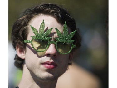 A young man sports green dope glasses at the annual 4:20 marijuana event held at it's new location, Sunset Beach, Vancouver April 20 2016.