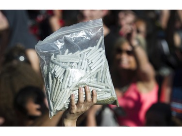 Joints are moved to the crowd for free distribution at the annual 4:20 marijuana event at it's new location, Sunset Beach, Vancouver April 20 2016.