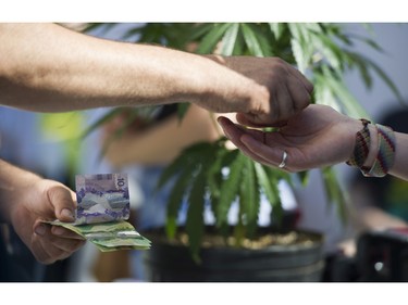 Money changes hands at a vendor in the market of the annual 4:20 marijuana event at it's new location, Sunset Beach, Vancouver April 20 2016.